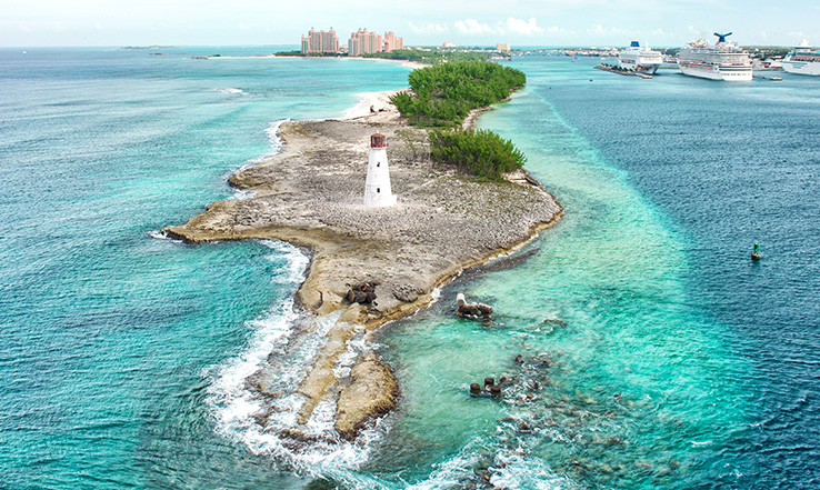 Aerial view of an island with a lighthouse on it.