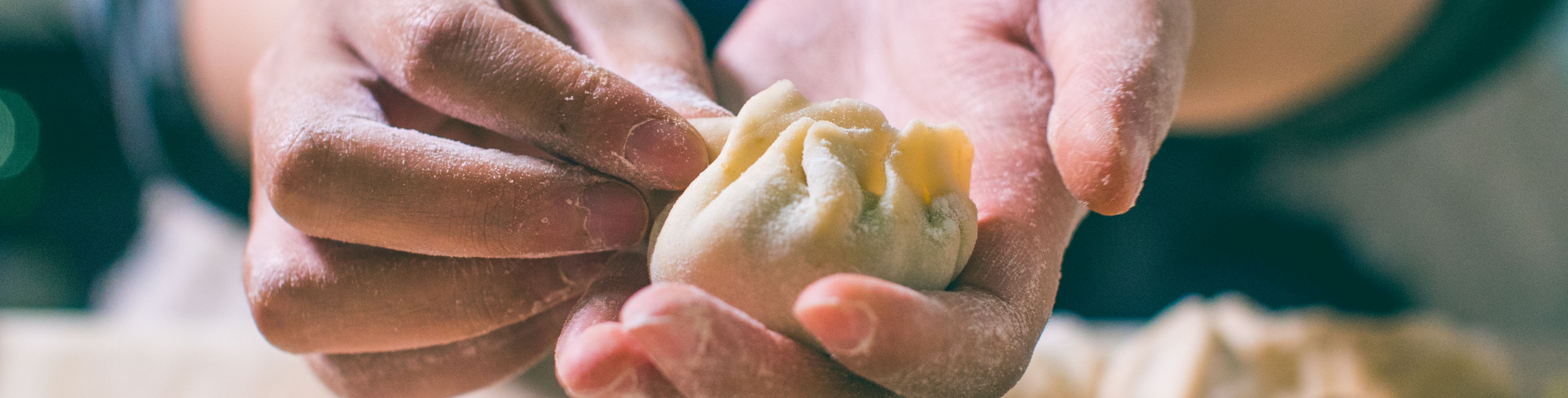 Person making dumplings with their hands. 