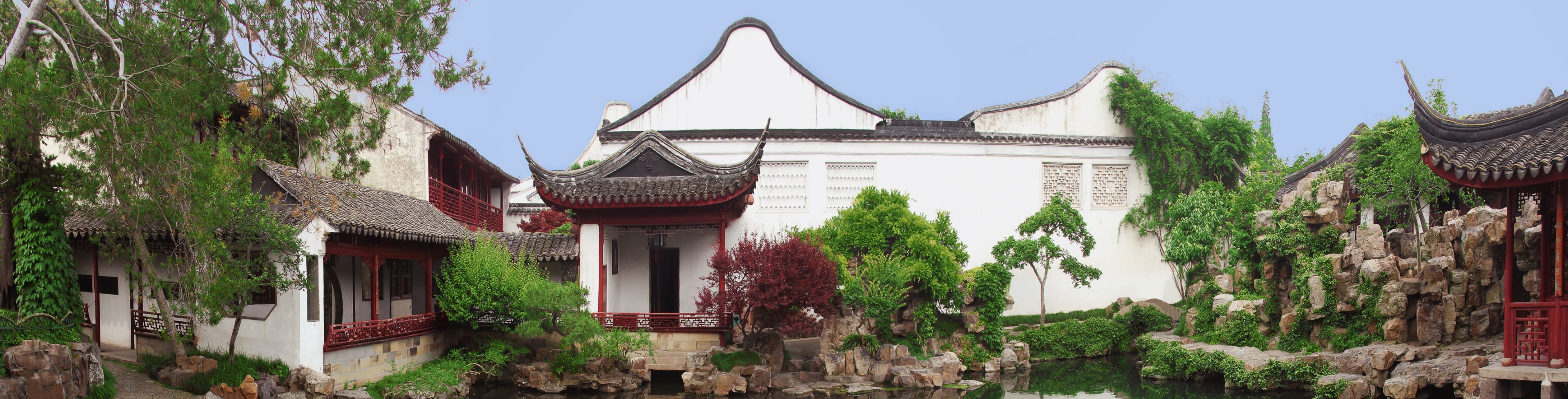 Garden area in behind a white building. 