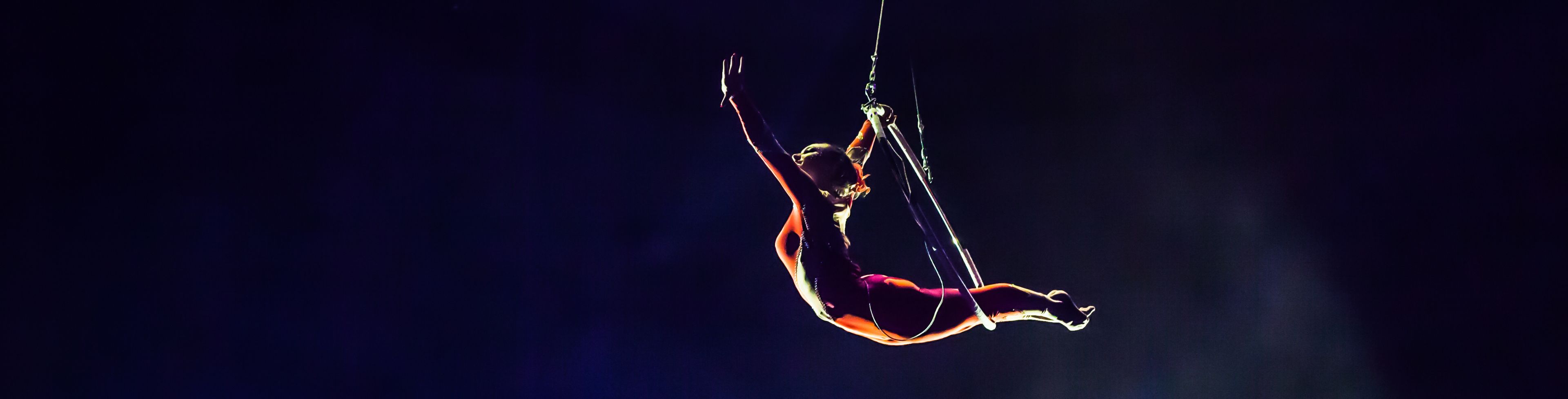 Acrobat in the air with a hoop. 