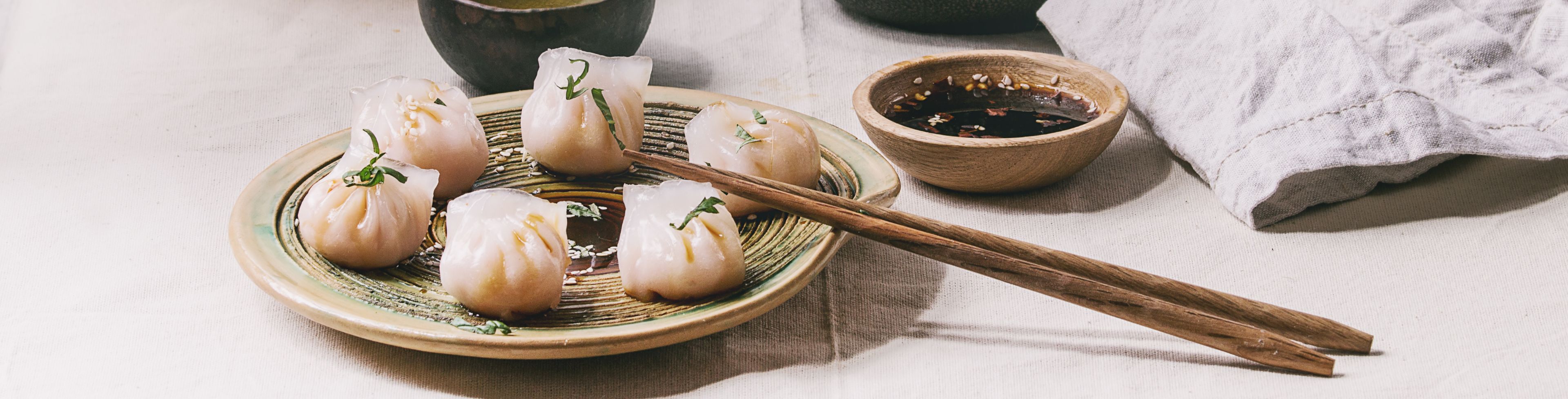 Dumplings, tea, and serving containers on the table. 
