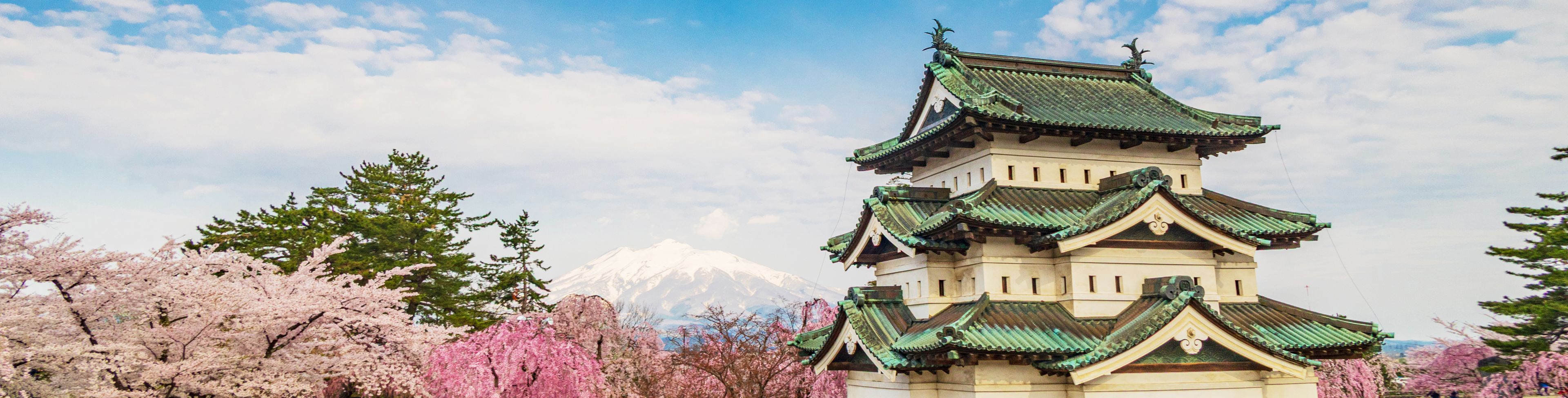Temple on some grounds surrounded by grass and trees. 