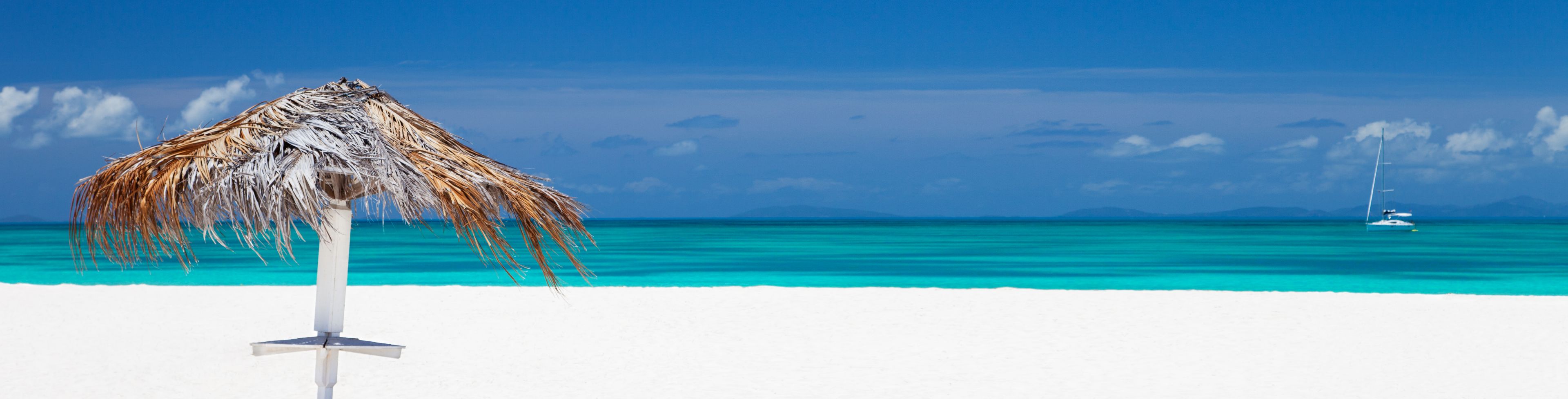 Straw umbrella on a white sandy beach. 