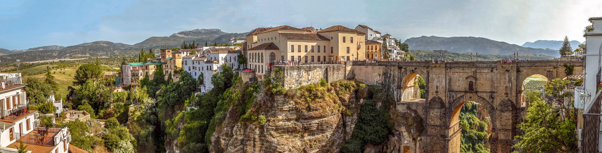 A villa sits cliffside with several more behind it. 
