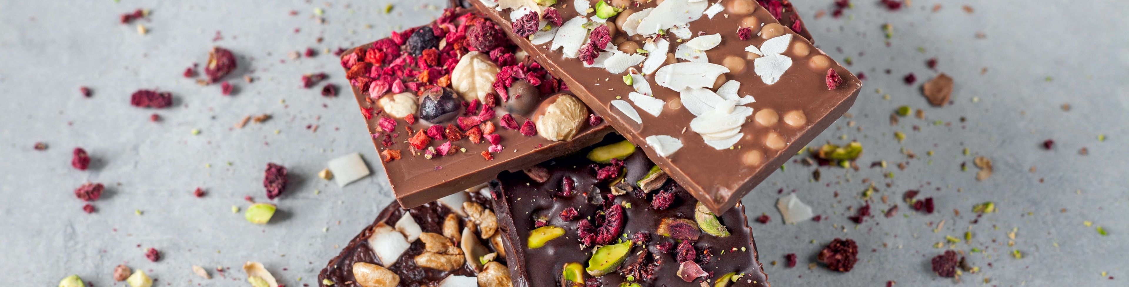 Different chocolate bars sit stacked on top of one another.