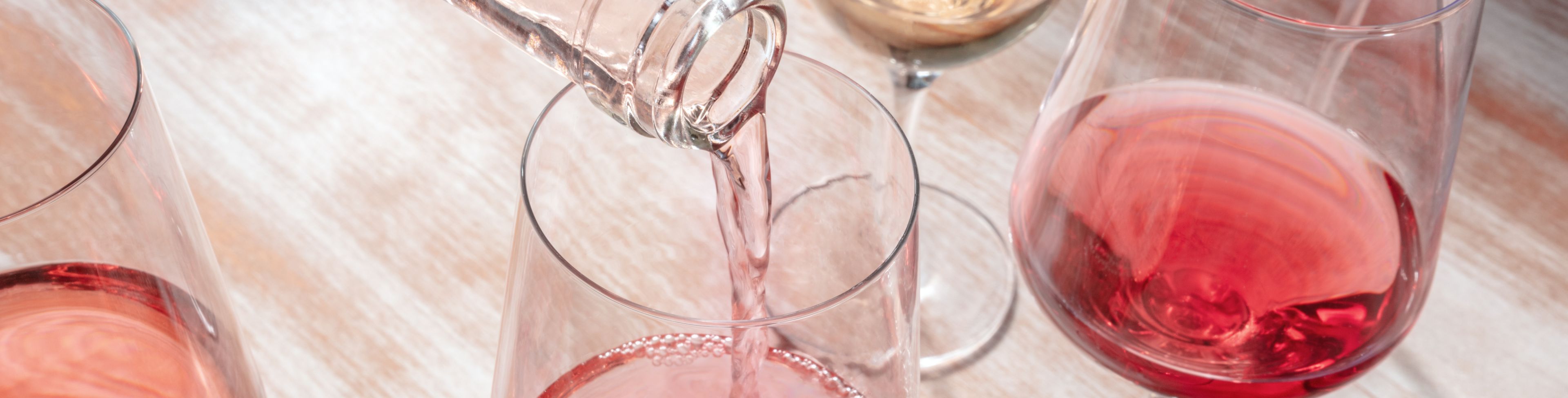 Multiple glasses partially filled with wine. 