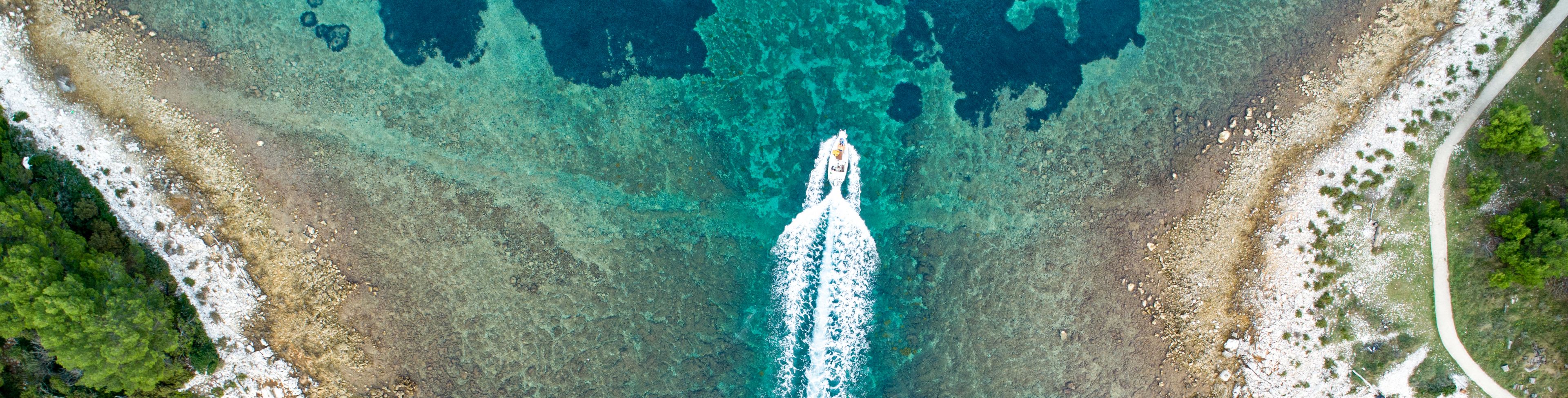 Sky view of a boat boating on the ocean.