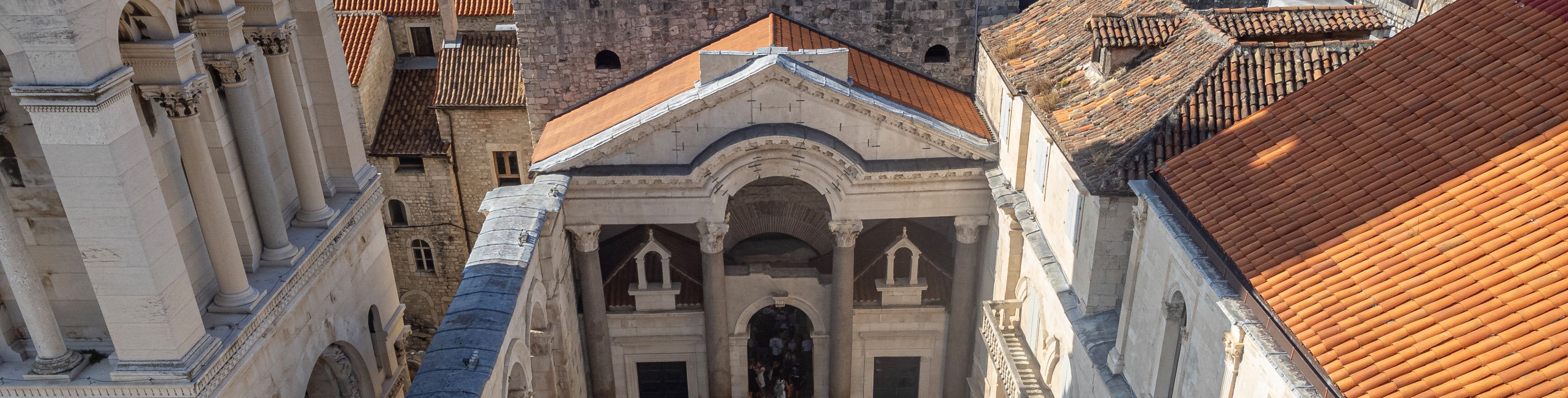 Rooftop view of courtyard full of people between buildings.