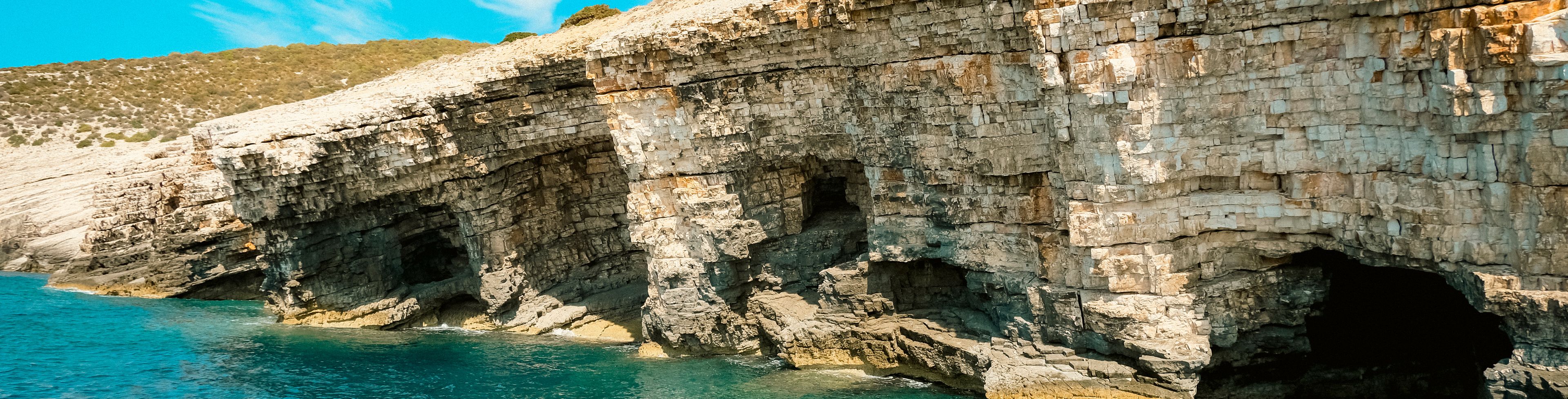 Cliffs with caves and water flowing inside them.
