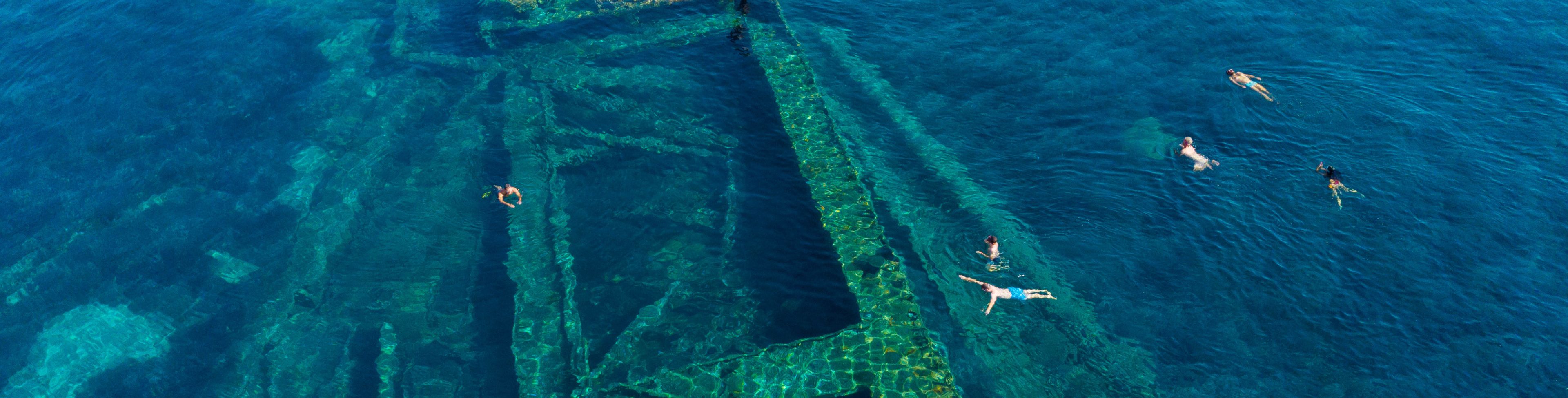 Old ship remains below the surface of the ocean.