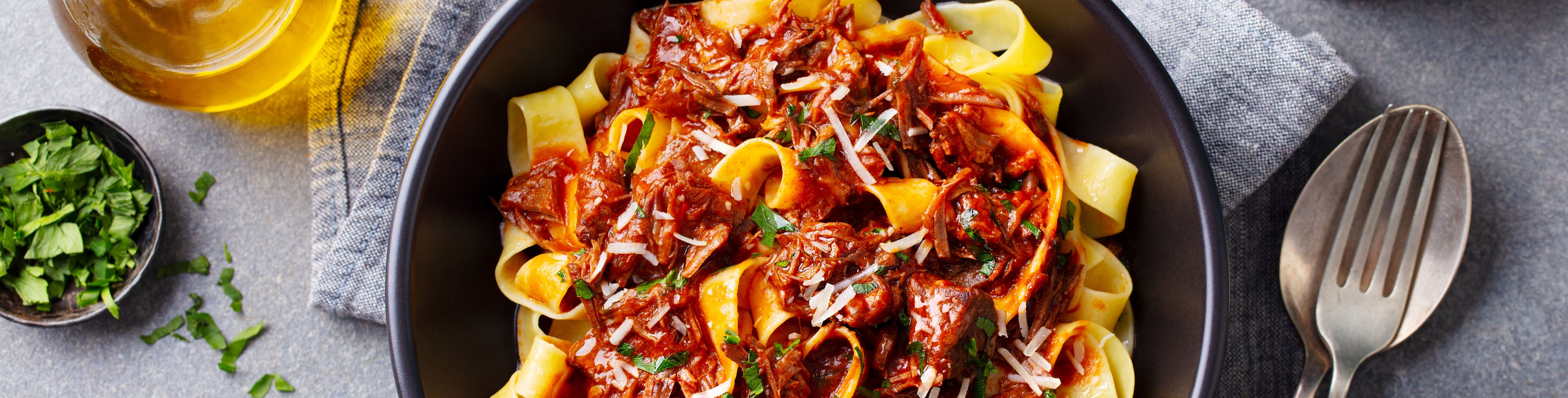 Pasta dish on table ready for someone to eat.