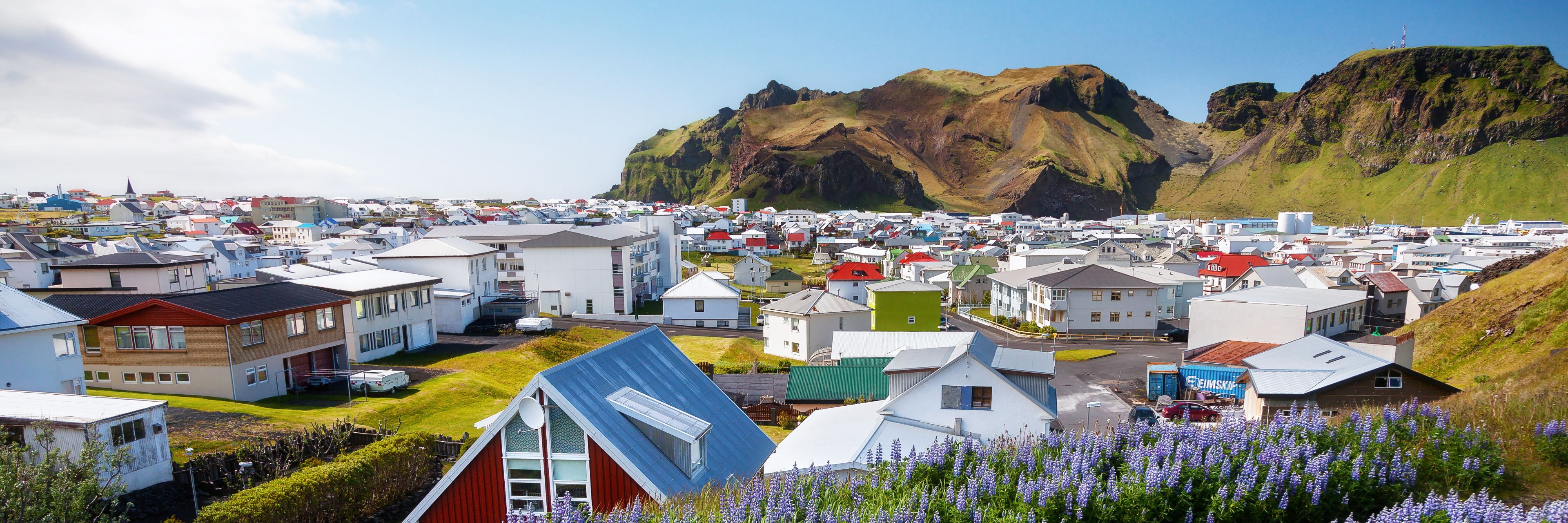 Town of homes with large rocky hills in the distance. 