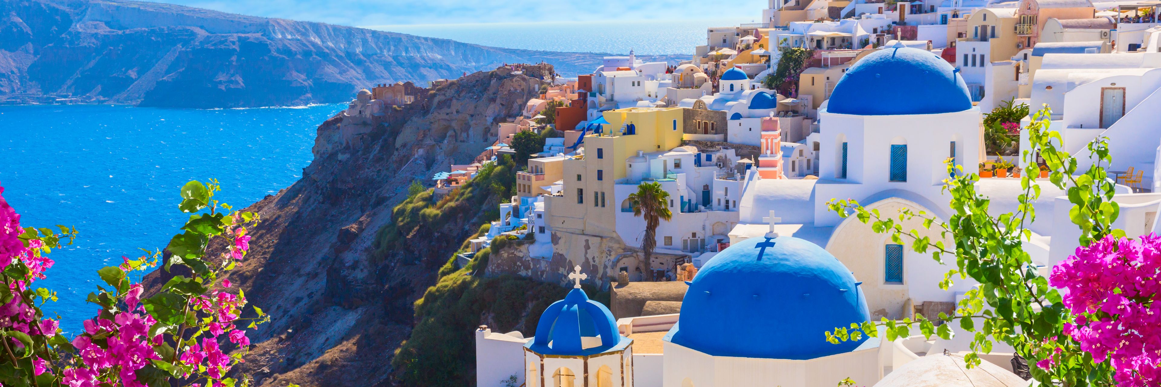 A city on a cliffside overlooking the ocean below.