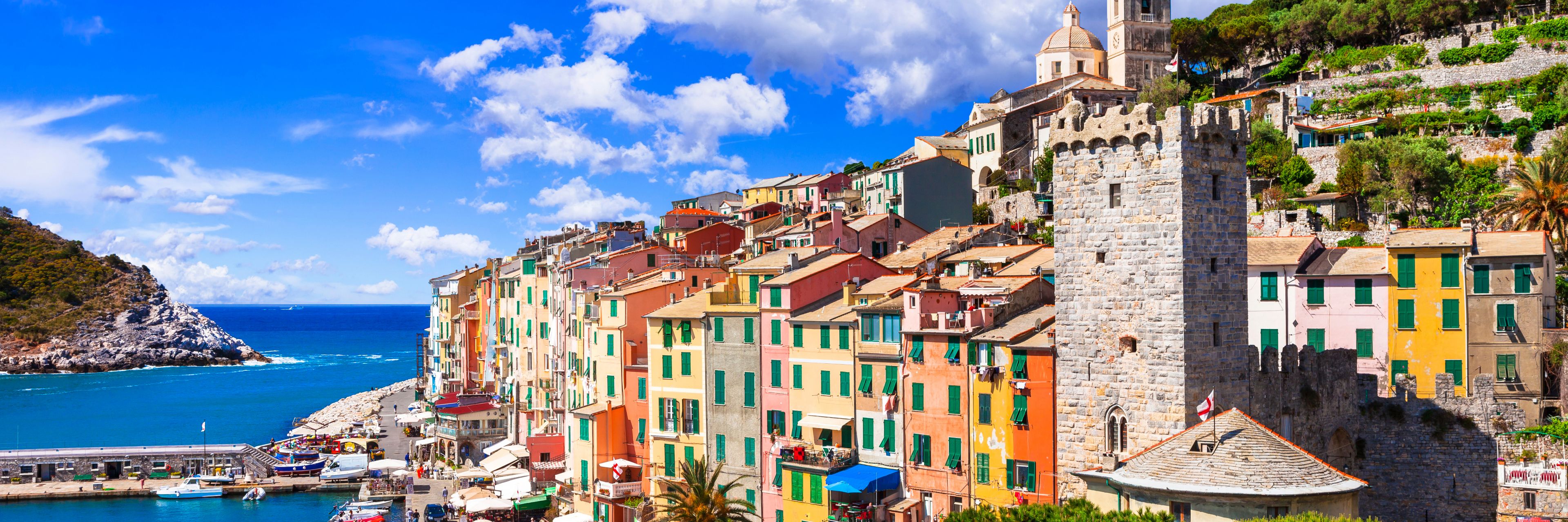 City buildings going up a hillside, facing the ocean. 