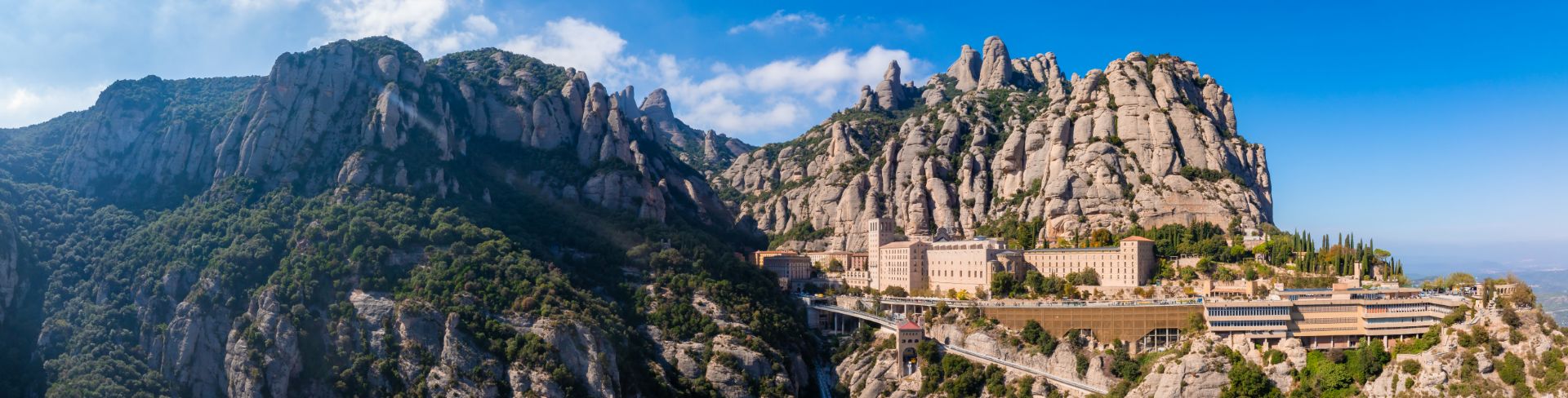 A rocky, mountainous formation sits behind a city.