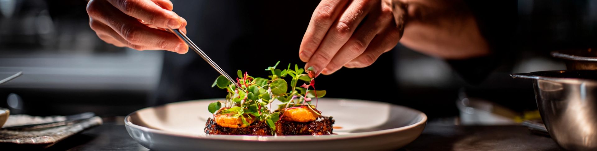 A person finishes the plating on a dish.