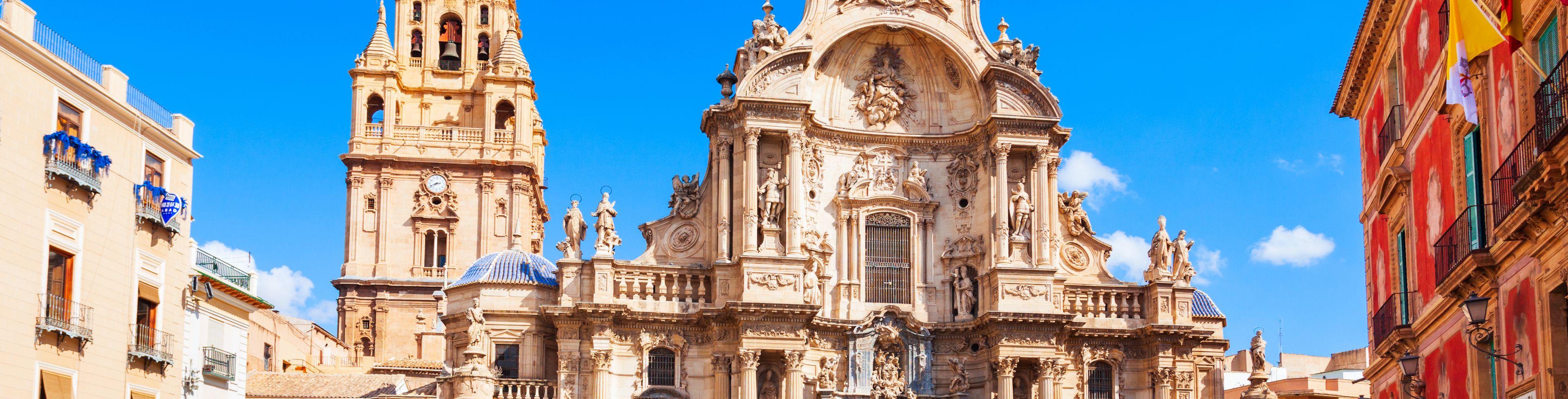 A church sits before bright blue skies behind a public plaza. 