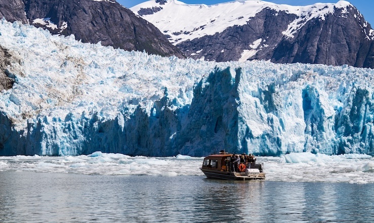 A boat heading toward the glacier and mountains.