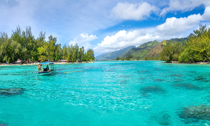 Small boat on clear blue ocean water.