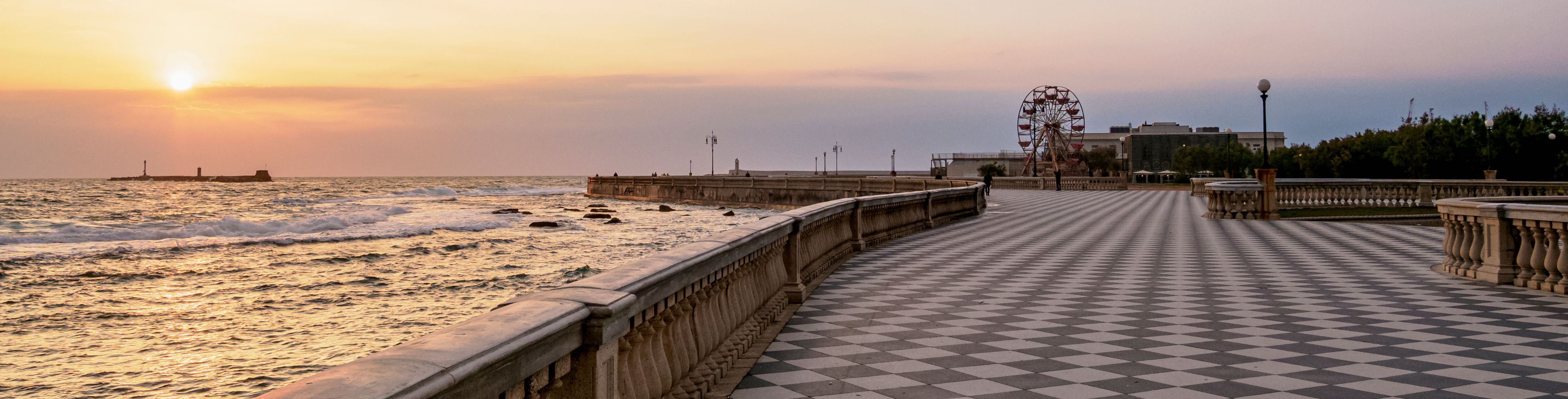 Boardwalk overlooking the ocean at sunset.
