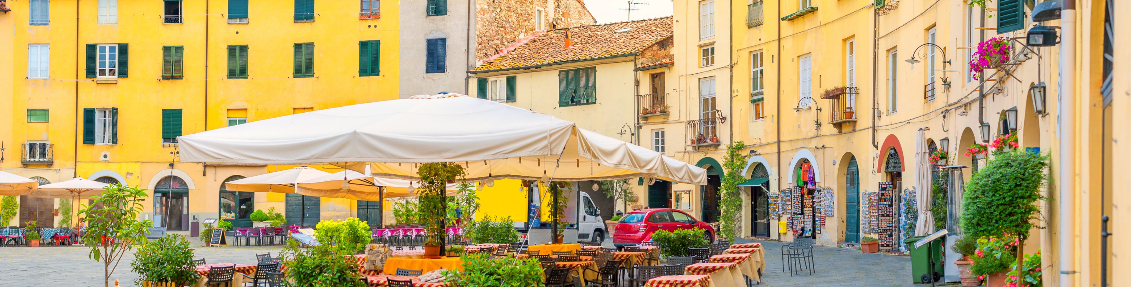 Chairs and tables set up, surrounded by buildings.