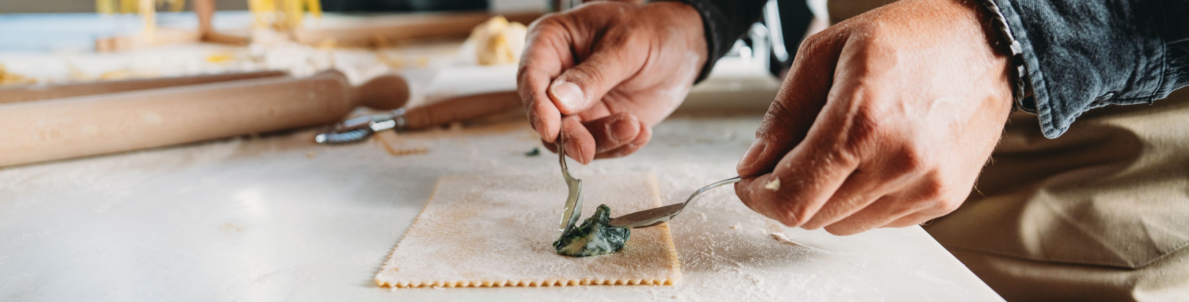 Person making pasta on counter.