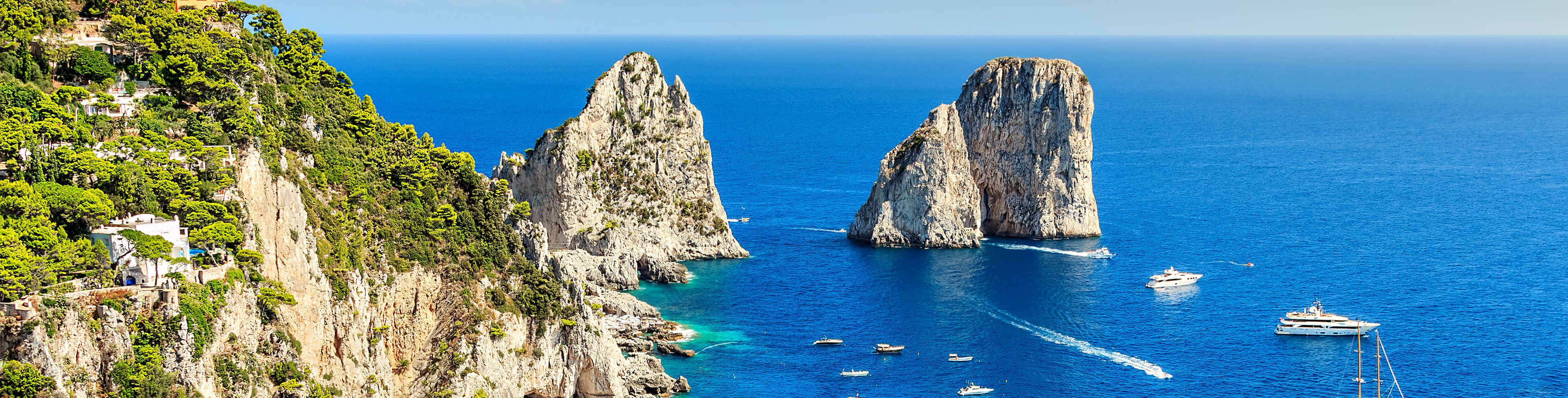 A variety of boats anchored near cliffs.