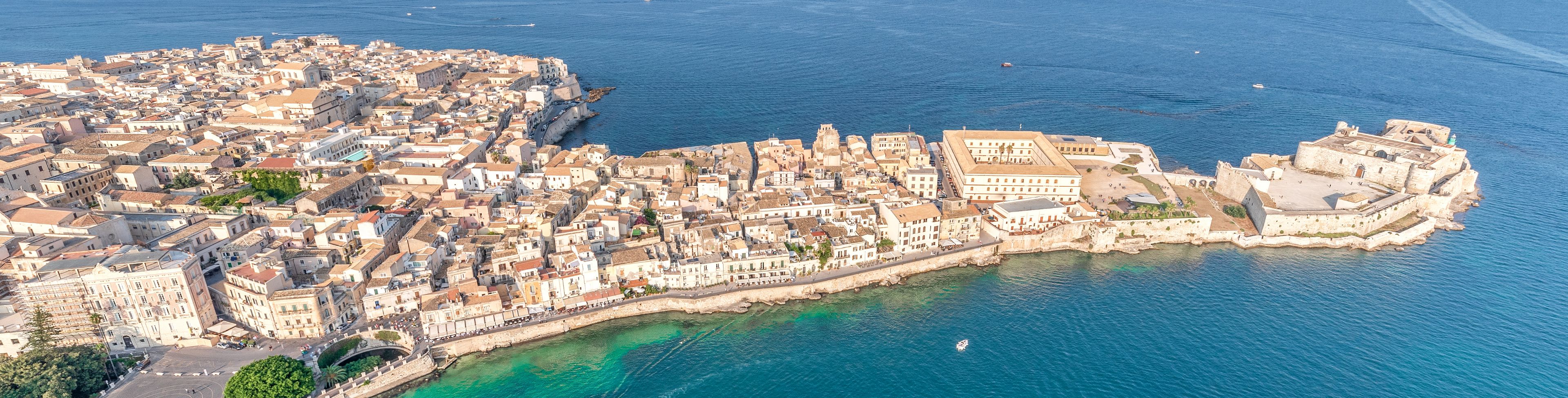 Sky view of water meeting the edge of Siracusa city.