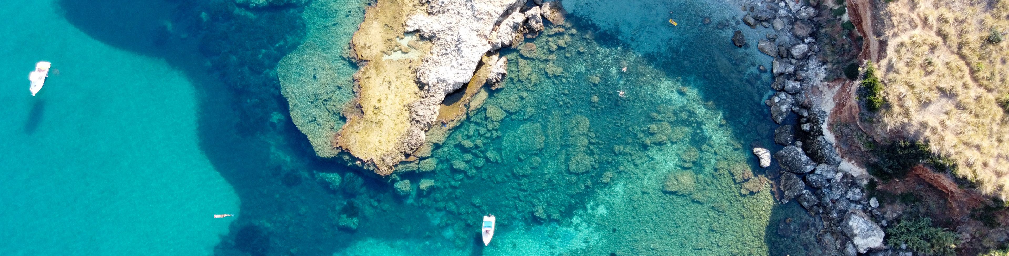 Sky view of boat anchored in a bay.