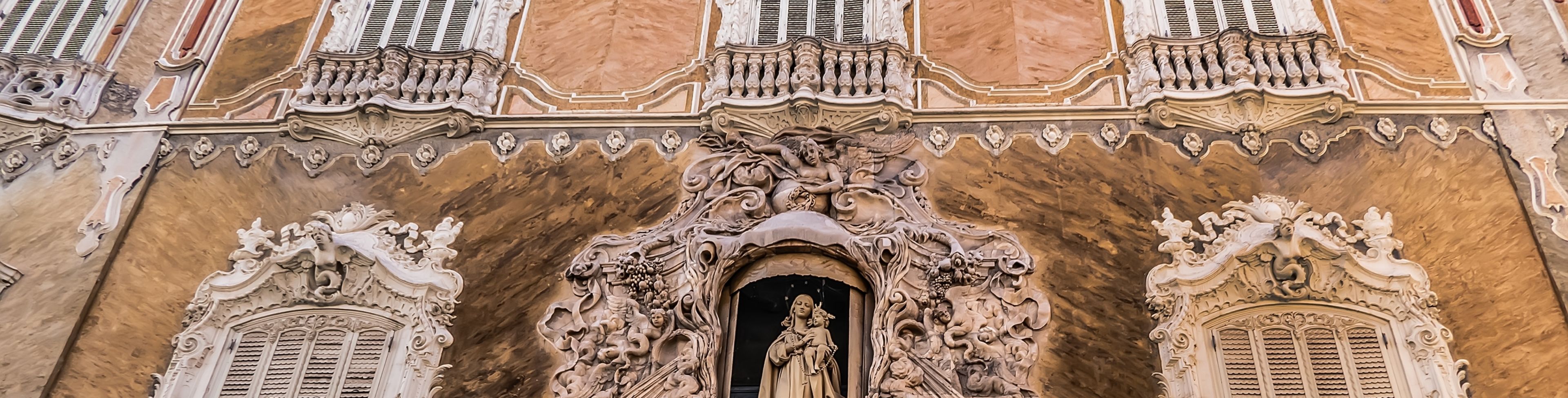Street view of an old building with a statue on the front.