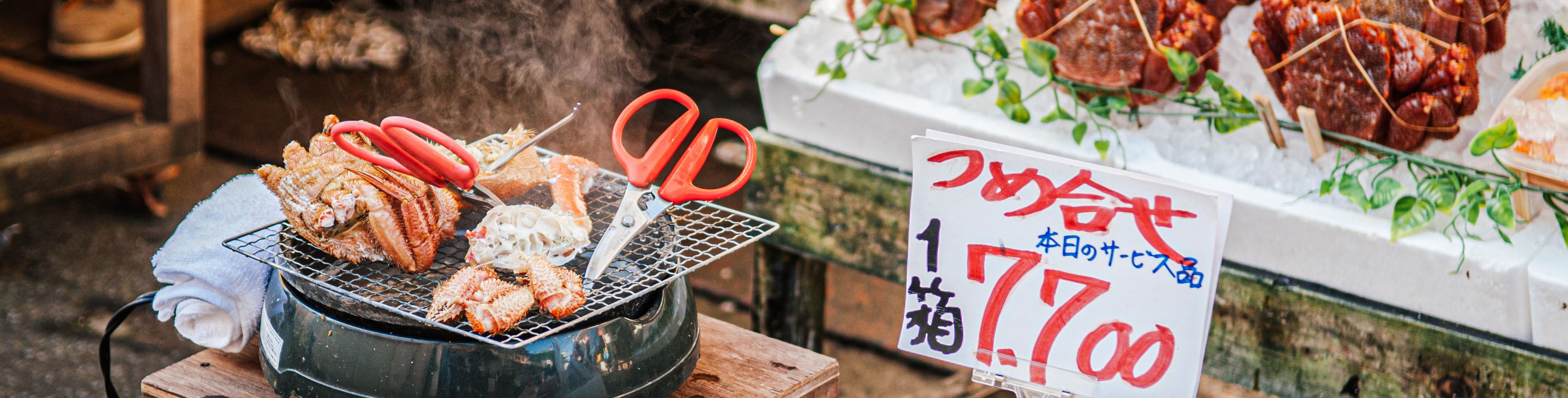 Food market food being cooked and displayed at a stand.