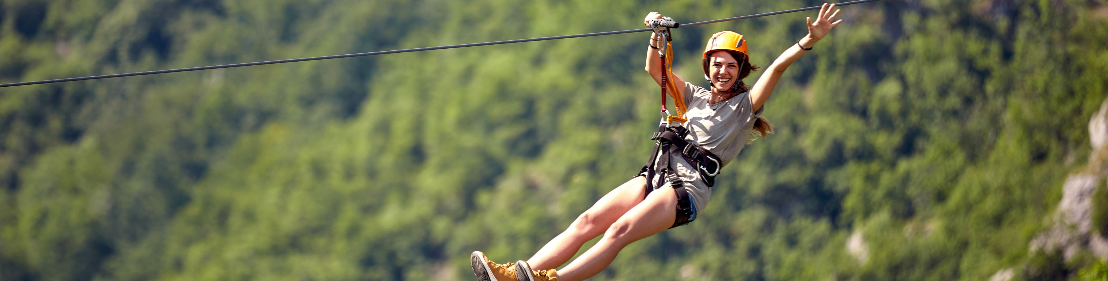 Woman ziplining while smiling.