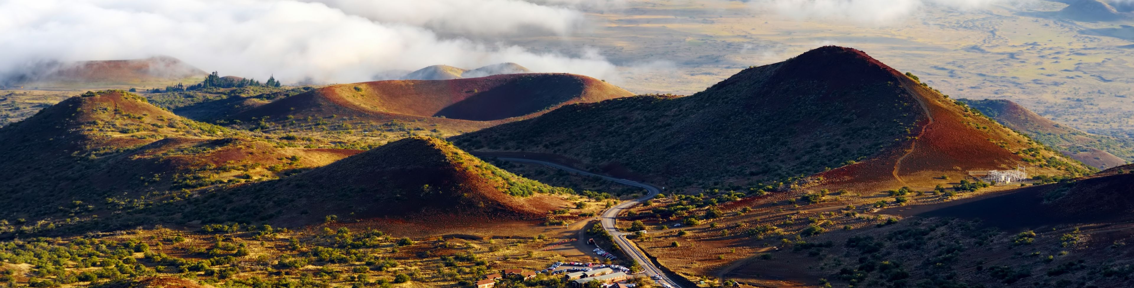 Hills and valleys with a road winding between them.