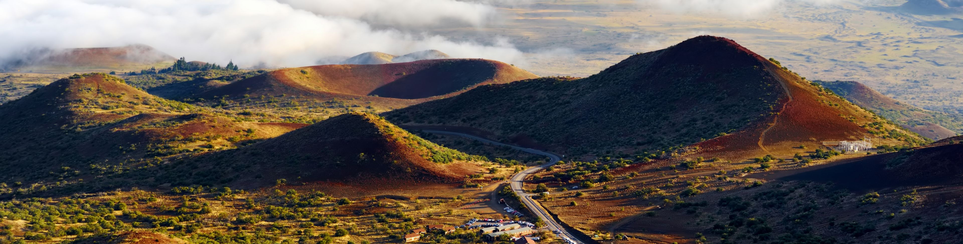 Hills and valleys with a road winding between them.