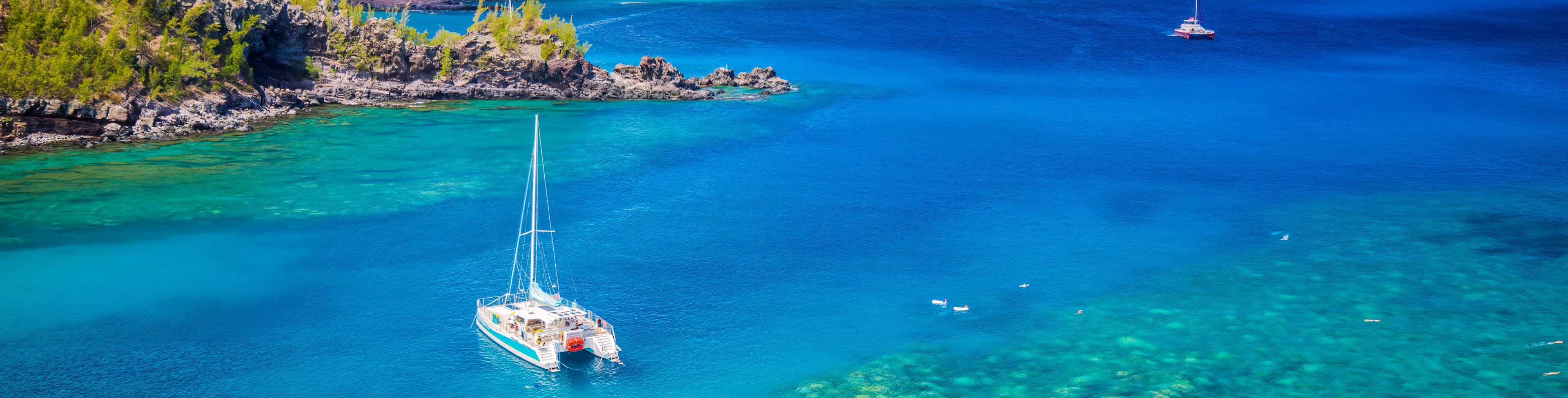 Catamaran anchored in the water close to shore.