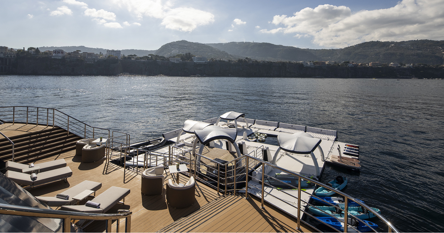 View of back of yacht with different water activities for guests.